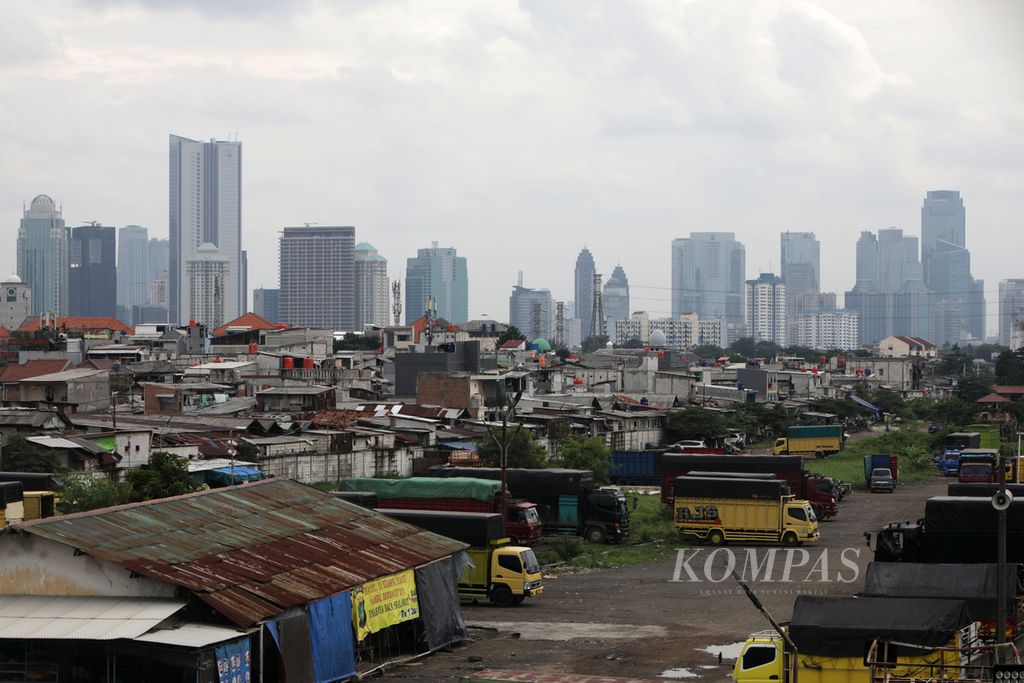 Perkampungan padat penduduk dengan latar belakang gedung bertingkat di Jakarta, Jumat (23/12/2022). 