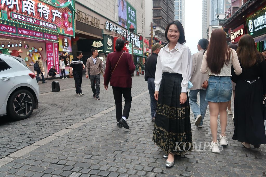 Sabrina Huang (30) dari Guangzhou mengenakan <i>mamianqun</i> atau rok lipit wajah kuda saat berkunjung ke Pozi Street di Changsha, Hunan, China, Kamis (11/5/2023). Gerakan neo-China terlihat dalam busana perempuan muda di jalanan China. Mereka memadukan baju tradisional dengan sentuhan modern.