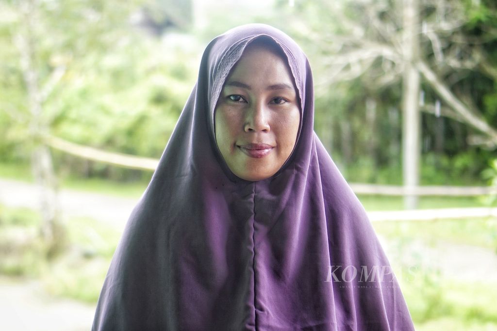 Yati Dahlia (31) berpose di halaman rumahnya di Desa Bumi Harapan, Kecamatan Sepaku, Penajam Paser Utara, Kalimantan Timur, Minggu (20/3/2022).