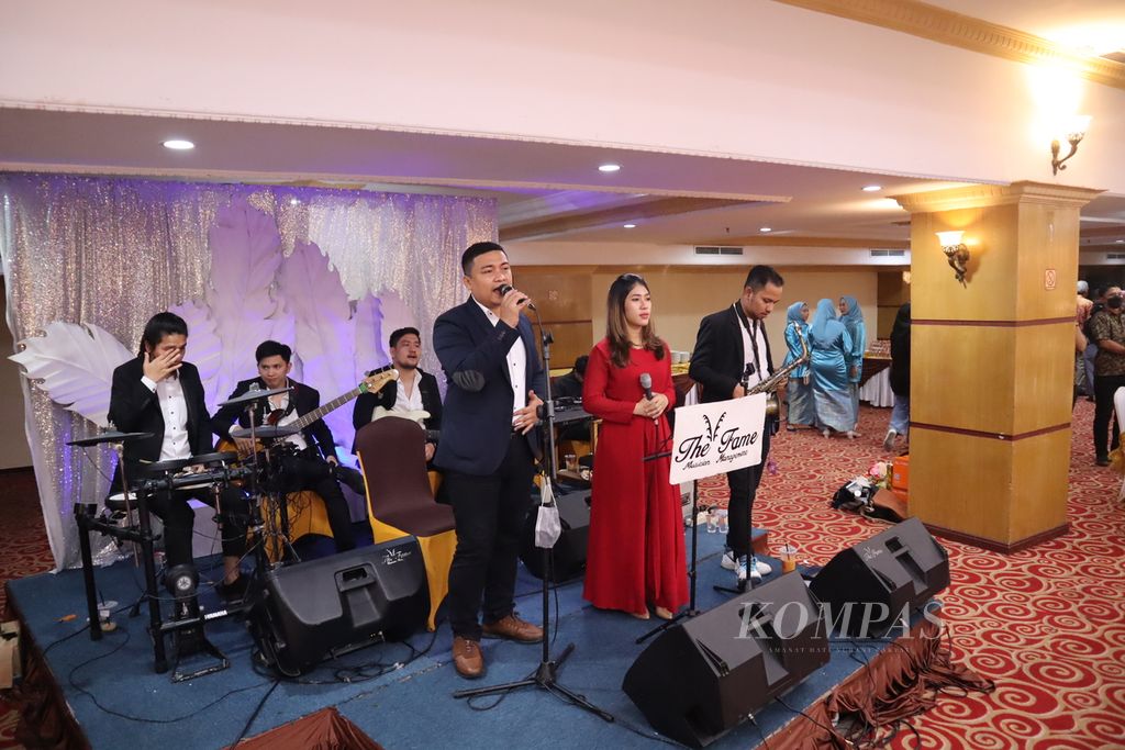 Singers and musicians from the music group "The Fame" perform at a wedding party at a hotel in Medan, Sunday, (2/13/2022). Music with a complete accompaniment band is a necessity in a party in Medan City..