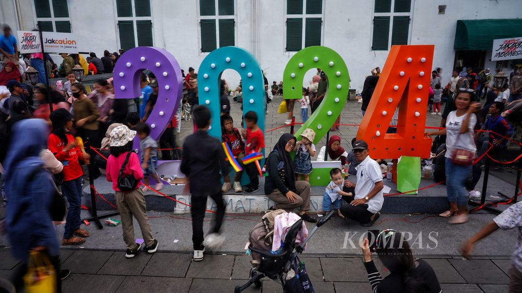 Hiasan instalasi bertulisakan 2024 menjadi wahana berfoto pengunjung di kawasan wisata Kota Tua, Jakarta, saat libur Tahun Baru 2024, Senin (1/1/2024). Kini liburan telah usai. Saatnya untuk bekerja atau kuliah lagi.
