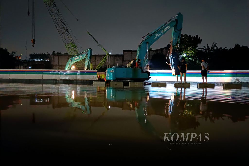 Alat berat digunakan untuk membongkar beton pembatas jalan tol saat banjir menggenangi Jalan Tol BSD Kilometer 8+500, ruas Pondok Aren-Serpong, Kota Tangerang Selatan, Banten, pada 6 Oktober 2022.