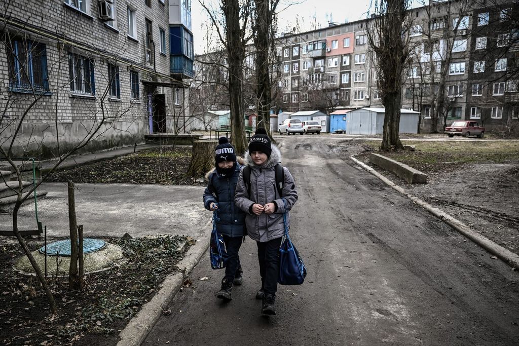 Dua anak berjalan di kota Avdiivka, Ukraina timur, 21 Februari 2022. 