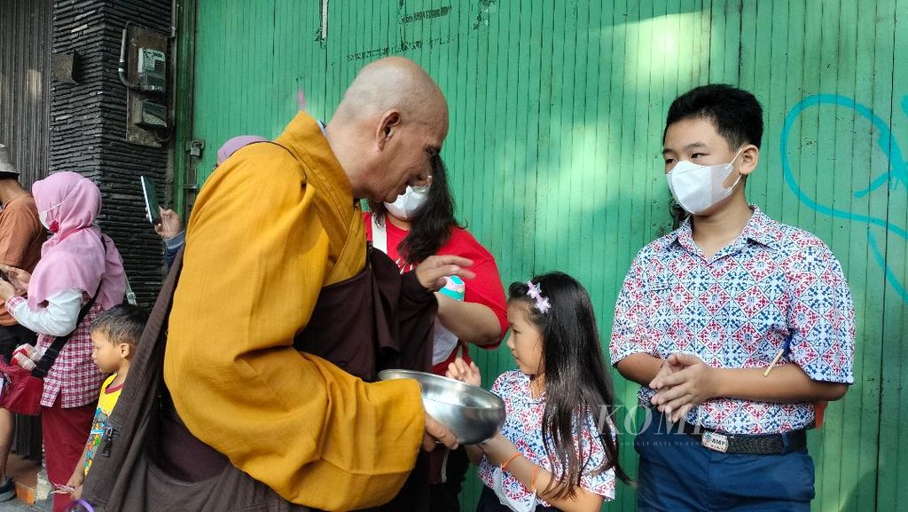Seorang biksu menerima derma makanan dari seorang anak yang berdiri di kawasan pecinan, Kota Magelang, Rabu (31/5/2023).