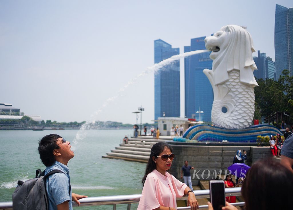 A number of tourists take photos at Merlion Park, Singapore, Sunday (29/9/2020).