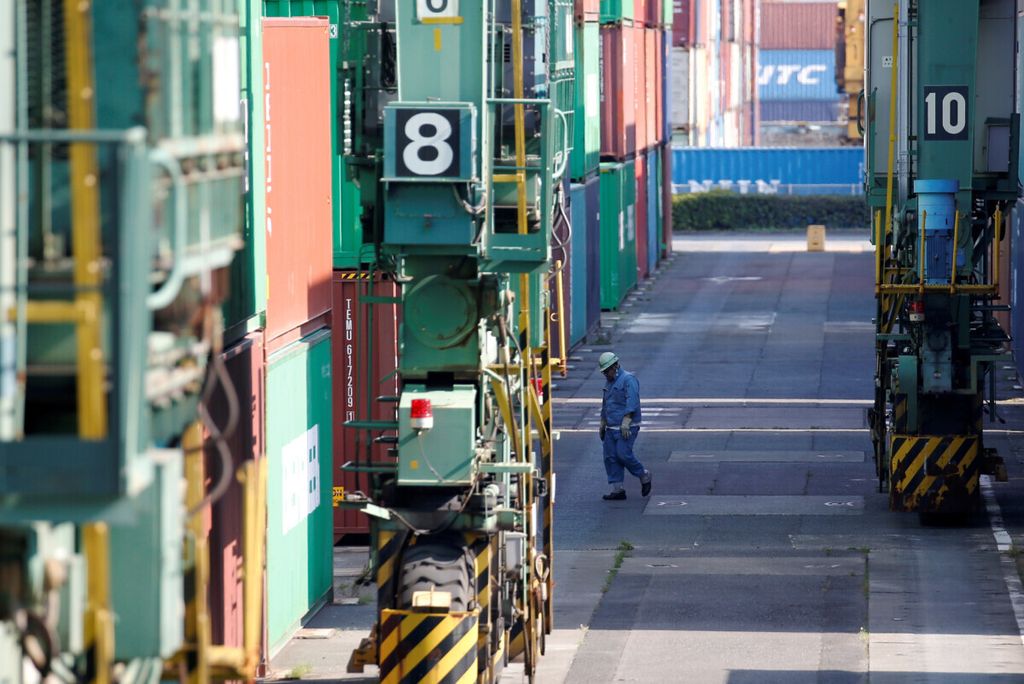 Seorang pekerja di antara peti kemas di pelabuhan Tokyo, Jepang pada MAret 2017.  Sebagian besar warga Jepang terbiasa bekerja dalam waktu panjang di satu tempat kerja. 
