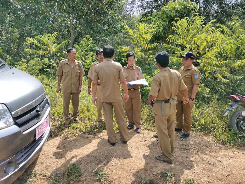 Mobil dinas inspektorat yang memasuki kawasan jalan usaha tani yang dibuat tahun 2017 di Desa Kinipan, Kabupaten Lamandau, pada pertengahan tahun 2020. Terlihat saksi Umar (memakai topi, kedua dari kiri) dari inspektorat juga hadir dalam kegiatan tersebut.