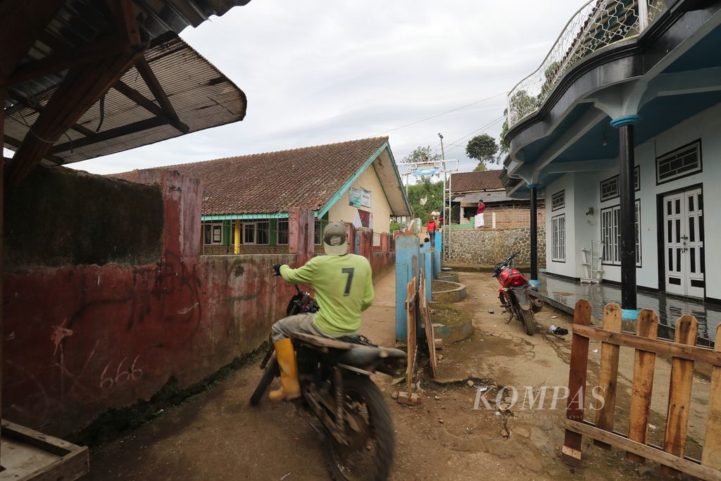 Warga melintasi jalan kecil antar pemukiman di Desa Cikembang, Kecamatan Kertasari, Kabupaten Bandung, Minggu (5/2/2023), Desa Cikembang di hulu Sungai Citarum ini pernah dilanda banjir bandang besar tahun 2021 lalu.