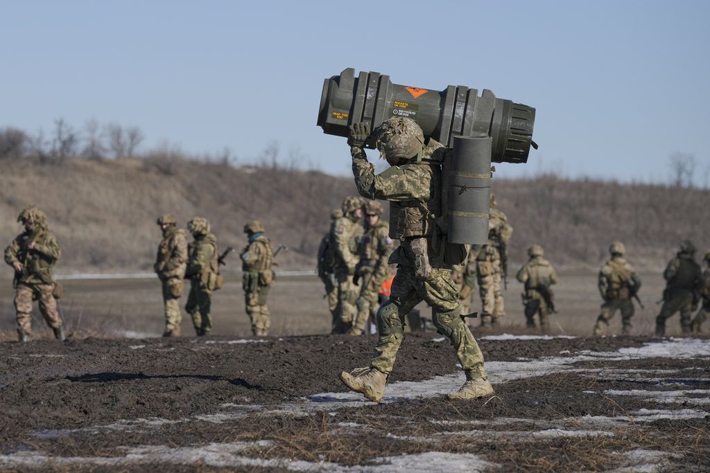 Seorang tentara Ukraina tengah membawa rudal anti-tank NLAW jelang latihan bersama di wilayah Donetsk, Ukraina timur pada Selasa (15/2/2022).