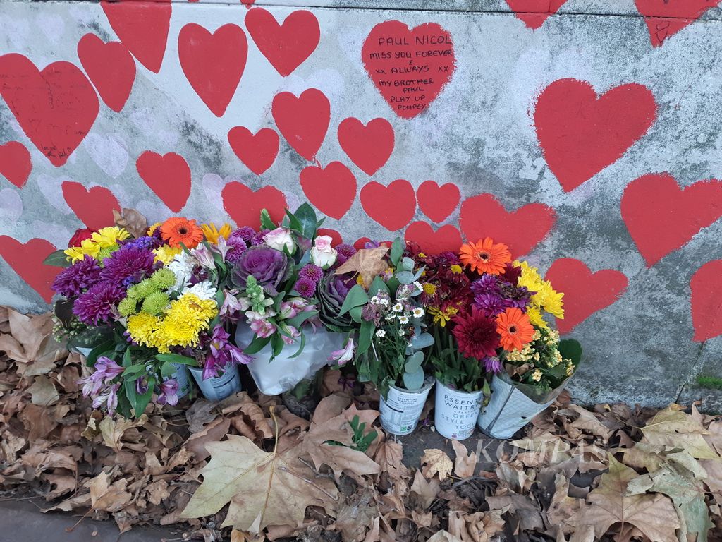Warga menaruh bunga di tembok peringatan pandemi Covid-19 di jalur pedestrian Albert Embankment, London, Inggris, Minggu (26/11/2023). Masih banyak keluarga dari warga yang sudah pernah terkena Covid-19 berdatangan ke tempat itu. Frasa <i>sudah pernah</i> bisa dihilangkan salah satunya dalam kalimat. 