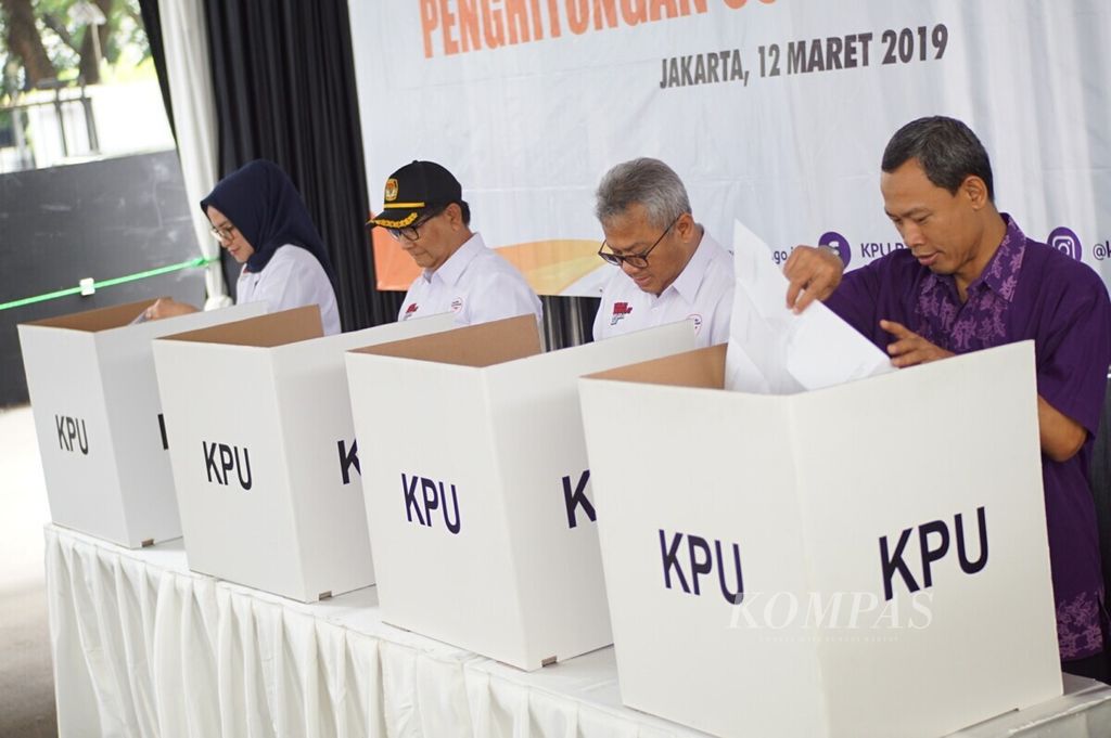 Jajaran pimpinan KPU periode 2017-2022, Arief Budiman (kedua kanan) dan Pramono Ubaid menyoblos di bilik suara saat simulasi pemungutan dan penghitungan suara yang diselenggarakan KPU di Halaman Kantor KPU, Jakarta, Selasa (12/3/2019).