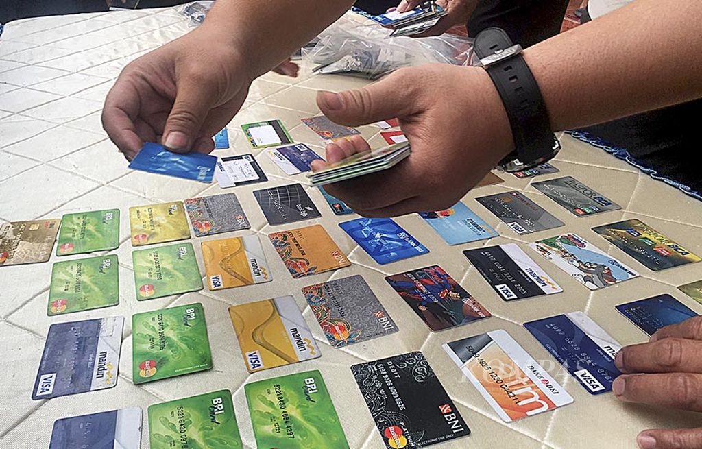 Puluhan kartu ATM yang digunakan komplotan penipu dan pencuri ATM diperlihatkan di Markas Polres Metro Jakarta Barat, Senin (14/8). Komplotan itu  menguras rekening para korban dengan berpura-pura menjadi pengusaha asal Brunei.