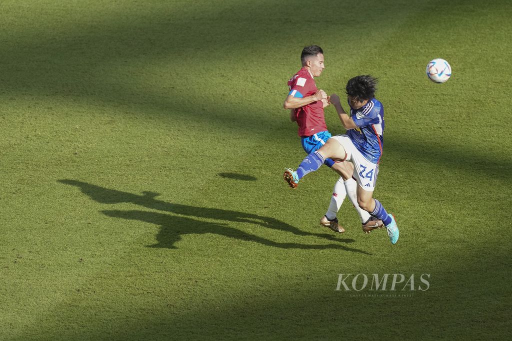 Pemain Jepang Yuki Soma berebut bola dengan pemain Kosta Rika Brian Oviedo di fase Grup E Piala Dunia 2022 di Stadion Ahmad Bin Ali, Qatar, Minggu (27/11/2022). Kosta Rika menang 1-0. 