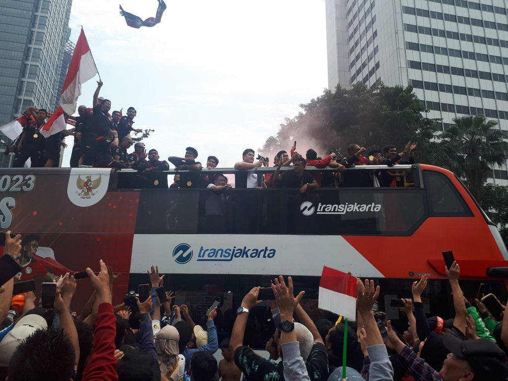 Para pemain dan pelatih Timnas U-22 menaiki bus Transjakarta bak terbuka pada arak-arakan di titik Bundaran Hotel Indonesia, Jakarta, Jumat (19/5/2023).