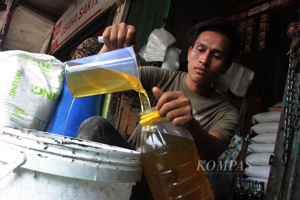Pedagang mengisi minyak goreng curah ke dalam botol di pasar tradisional Lambaro, Kabupaten Aceh Besar, Provinsi Aceh, Kamis (17/3/2022).