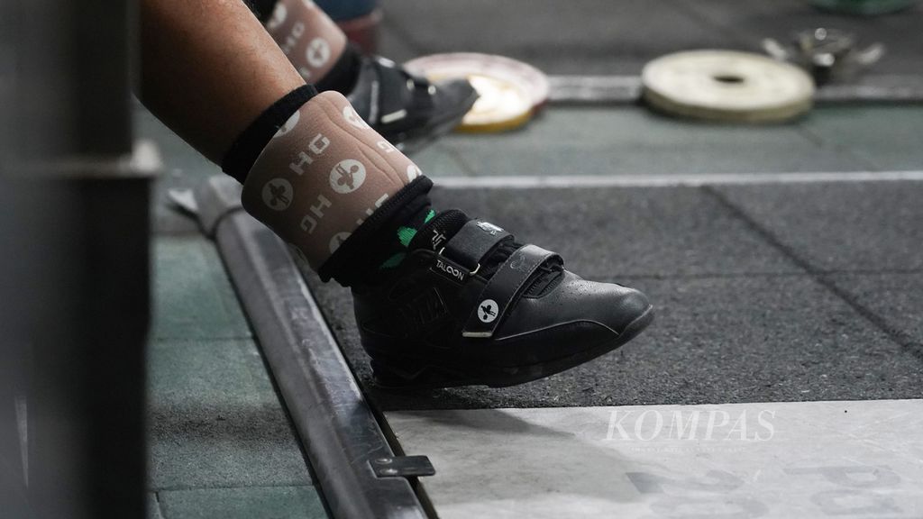 Sepatu khusus atlet angkat besi yang digunakan lifter nasional Rahmat Erwin Abdullah ketika mengikuti latihan di pelatnas angkat besi PB PABSI di Mako Marinir TNI AL, Jakarta, Senin (25/4/2022).
