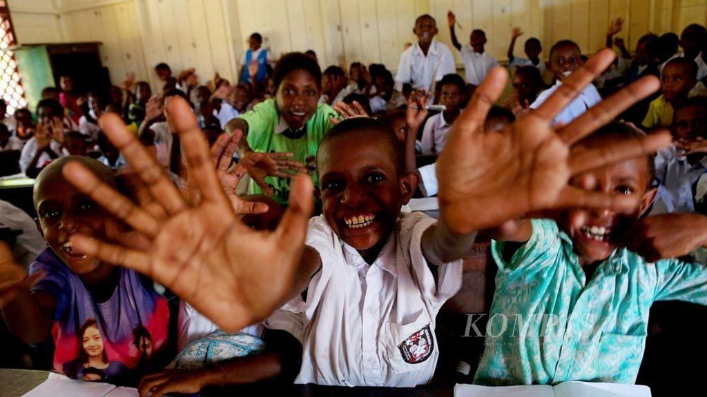 Sejumlah siswa kelas I SD YPPK Don Bosco Ewer, Kabupaten Asmat, Papua, melambaikan tangan mereka saat difoto di sela-sela jam belajar mereka di sekolah, Senin (22/1/2018). 