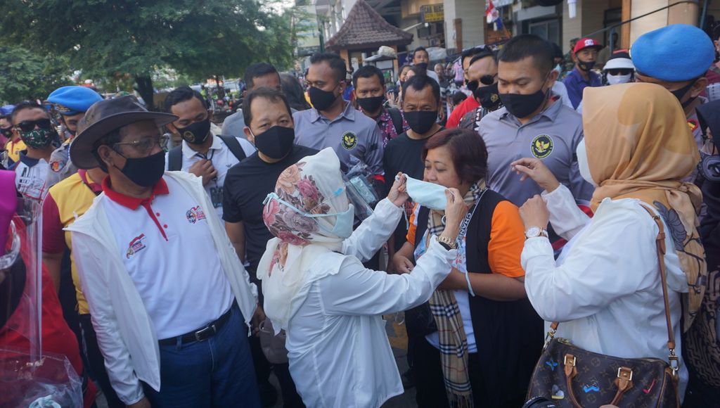 Zaizatun Nihayati, istri Menteri Koordinator Bidang Politik, Hukum, dan Kemanan Mahfud MD, memakaikan masker kepada salah seorang warga di kawasan Malioboro, Kota Yogyakarta, Minggu (30/8/2020). 