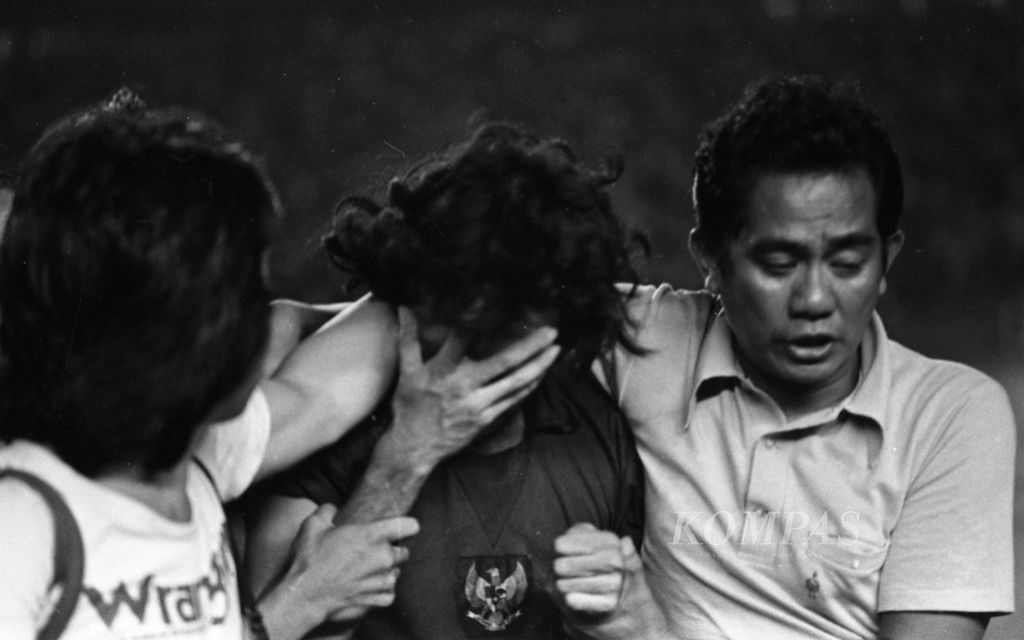 Indonesian attacking midfielder, Junaedi Abdillah, cried in tears after Indonesia suffered a penalty shootout defeat of 4-5 against North Korea in the final of the Pre-Olympic 1976 held on February 26, 1976 at Senayan Main Stadium, Jakarta. Junaedi was embraced by Assistant Coach Ilyas Haddade.