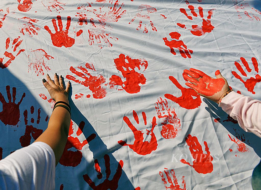 Masyarakat membubuhkan cap tangan sebagai dukungan terhadap gerakan ”Hentikan Kekerasan Seksual terhadap Perempuan dan Anak” yang digelar Seknas Perempuan Pendukung Jokowi di area bebas kendaraan Jalan MH Thamrin, Jakarta, Minggu (22/6/2017).