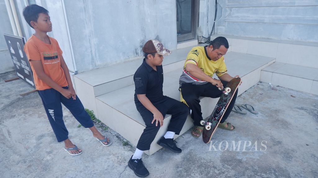 Brigadir Kepala Suhro Wardi, yang juga adalah Ketua RT 004 RW 001 Kelurahan Banua Anyar (berkaus kuning), memperbaiki papan seluncur atau <i>skateboard</i> di halaman Masjid Al-Haq, Banua Anyar, Kecamatan Banjarmasin Timur, Kota Banjarmasin, Kalimantan Selatan, Minggu (11/6/2023).