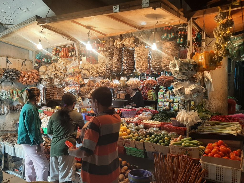 Pedagang sayur melayani beberapa pembeli di Pasar Tebet Timur, Jakarta Selatan, Jumat (14/10/2022).