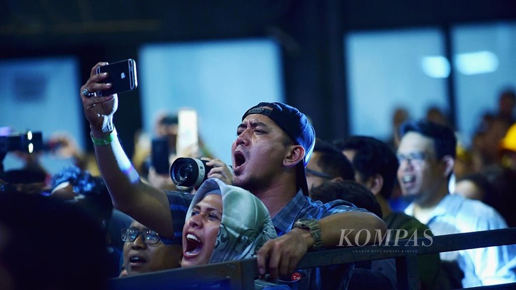 Pengunjung bernyanyi bersama saat band Vodoo tampil dalam Festival 90's di Jakarta, Sabtu (25/11).