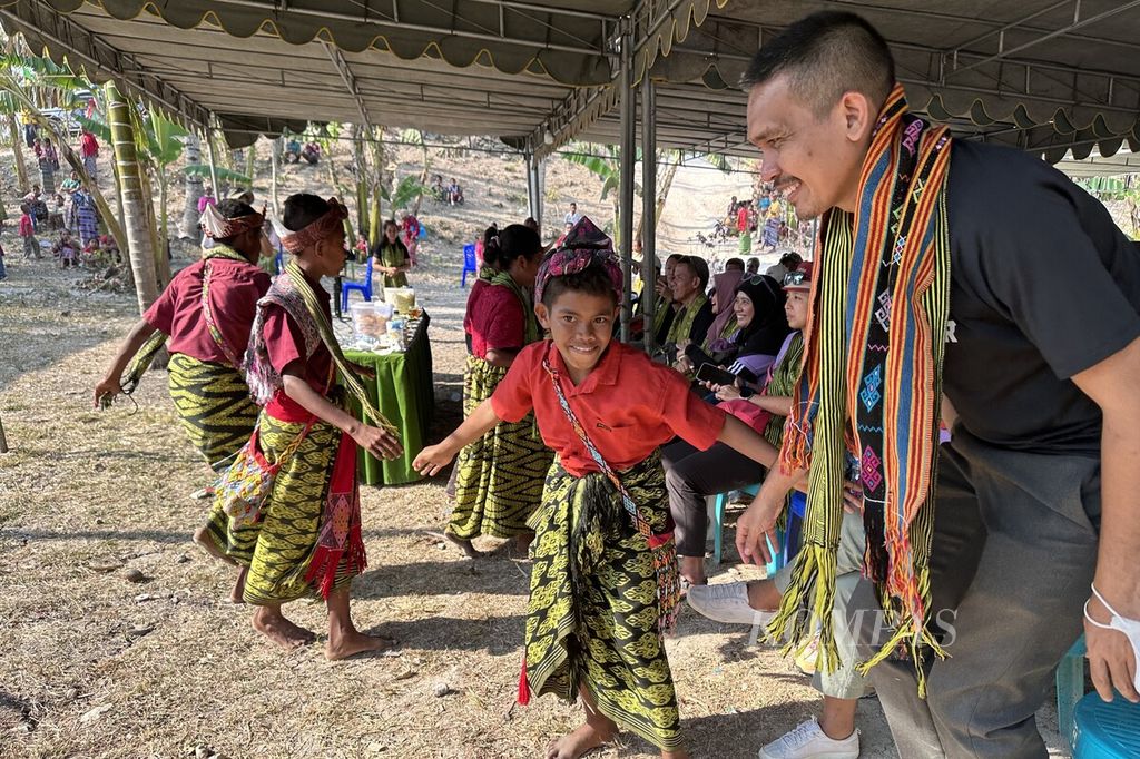 Peserta lari amal <i>ultramarathon </i>Jelajah Timur ikut menari dengan anak-anak Desa Naileu, Kecamatan Kie, Kabupaten Timor Tengah Selatan, Nusa Tenggara Timur, Kamis (26/10/2023). Kurangnya akses air bersih turut berkontribusi terhadap meningkatnya prevelensi tengkes di daerah itu.