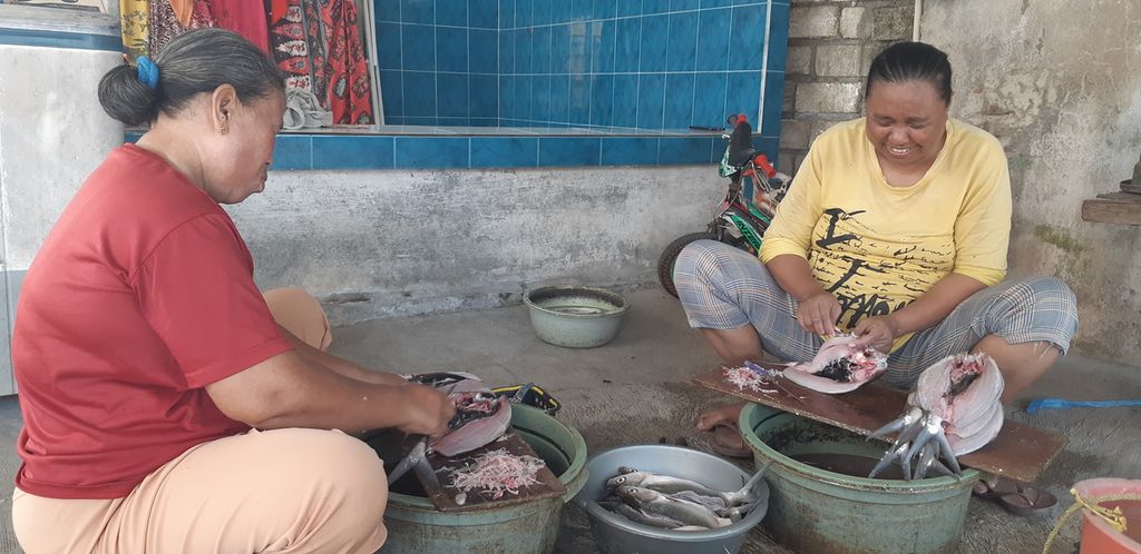 Zulfa (40), berkaus kuning, sedang mencabut duri ikan bandeng di rumahnya di lingkungan RT 017 RW 004 Desa Kalanganyar, Sidoarjo, Jawa Timur, Minggu (29/10/2023). Dia menerima 25-30 ekor bandeng untuk cabut duri dengan jasa Rp 1.500 per ekor.