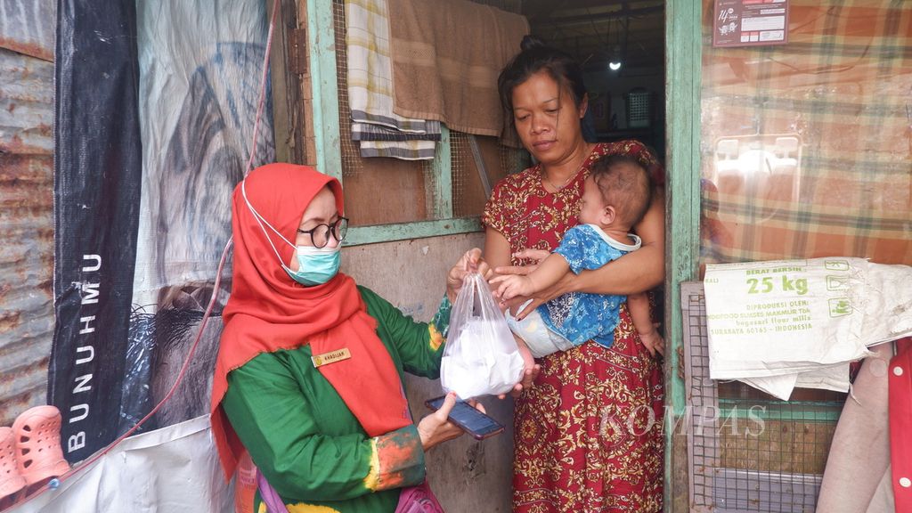 Seorang kader Bina Keluarga Balita Posyandu Lestari Kelurahan Kelayan Barat menyerahkan paket telur rebus kepada warga yang memiliki anak <i>stunting </i>di Kelurahan Kelayan Barat, Kecamatan Banjarmasin Selatan, Kota Banjarmasin, Kalimantan Selatan, Kamis (6/4/2023).