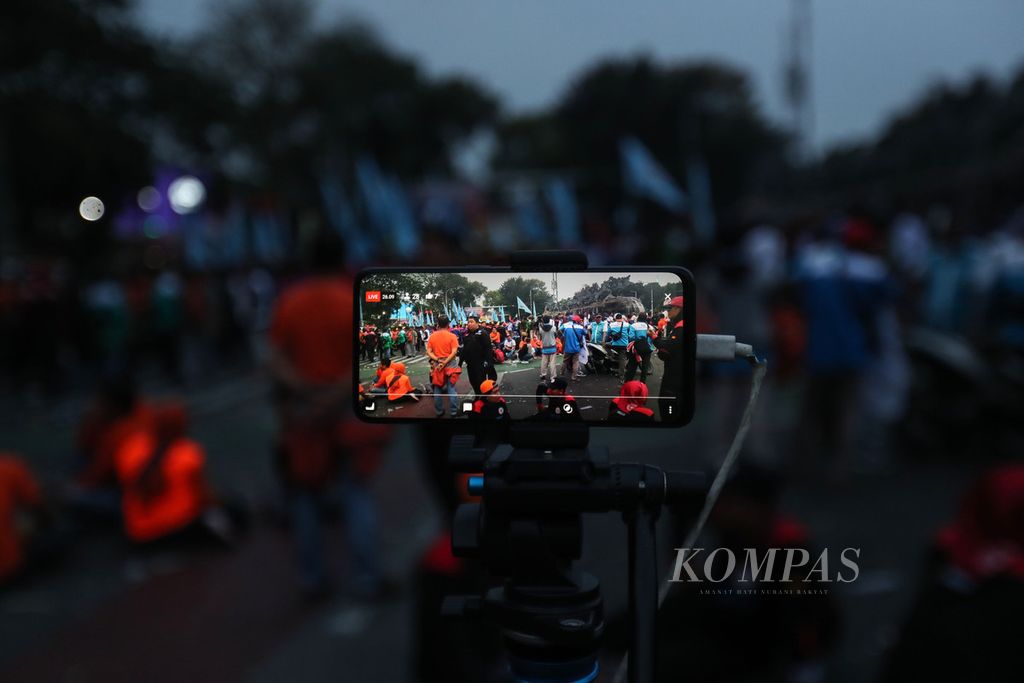 Ponsel salah seorang peserta aksi yang menyiarkan secara langsung demonstrasi di kawasan Patung Kuda Arjuna Wiwaha, Jakarta, Senin (2/10/2023).