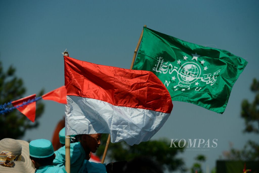 Anak-anak membawa bendera Merah Putih dan bendera Nahdlatul Ulama saat Hari Santri Nasional di Lapangan Bantir, Kecamatan Sumowono, Kabupaten Semarang, Jawa Tengah, Selasa (22/10/2019). 