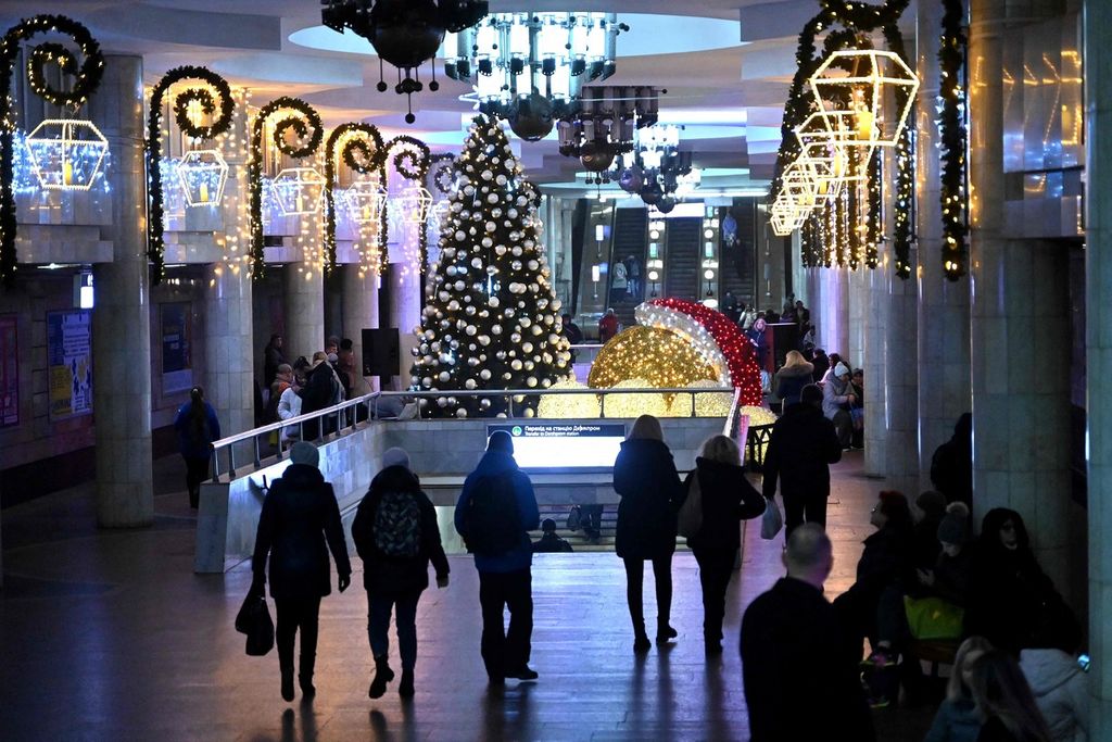 Penumpang berjalan di stasiun bawah tanah yang dihiasi dengan pohon Natal di Kharkiv, Ukraina, Jumat (22/12/2023). 
