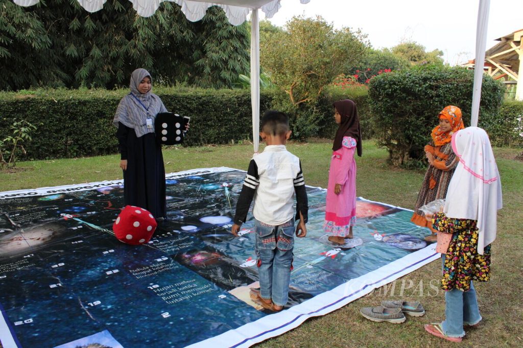Sejumlah anak mengikuti permainan ular tangga raksasa dalam rangkaian acara <i>open house</i> peringatan 50 tahun pendaratan pertama manusia di Bulan di Observatorium Bosscha, Kabupaten Bandung Barat, Jawa Barat, Sabtu (13/7/2019).
