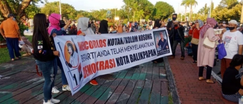 Sekelompok orang membentangkan spanduk yang berisi ajakan untuk mencoblos kotak kosong di Pilkada 2020 Balikpapan, Kalimantan Timur, pada 27 September 2020.