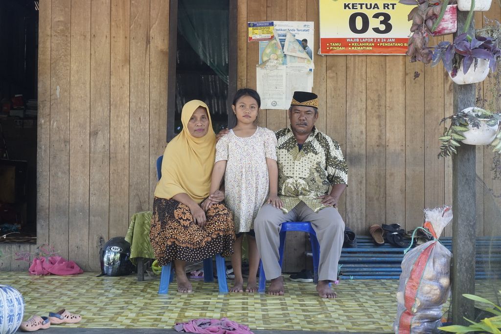 Pandi (49), istri, dan anak keenamnya berpose di depan rumahnya di RT 003 Kelurahan Sepaku, Kecamatan Sepaku, Penajam Paser Utara, Kalimantan Timur, Selasa (7/6/2022). Keluarga keturunan suku Paser dan suku Balik itu berharap masyarakat lokal dilindungi hak-haknya dalam pembangunan IKN Nusantara.