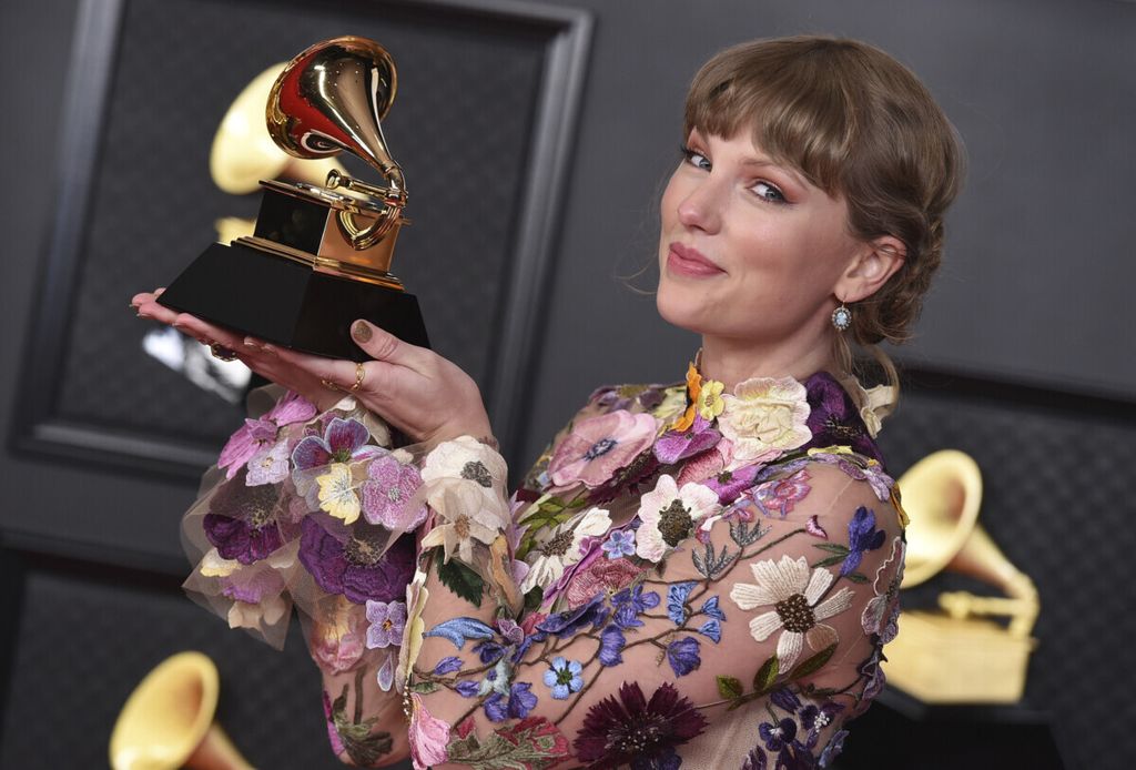 Taylor Swift berpose dengan penghargaan Grammy Awards di Los Angeles Convention Center, Minggu (14/3/2021).  