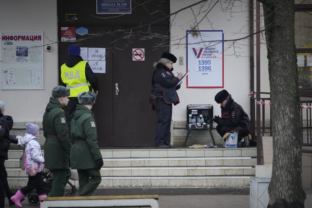Petugas polisi memeriksa lokasi setelah seorang wanita melemparkan bom molotov ke atap sekolah yang digunakan sebagai tempat pemungutan suara selama pemilihan presiden di St Petersburg, Rusia, 15 Maret 2024. 