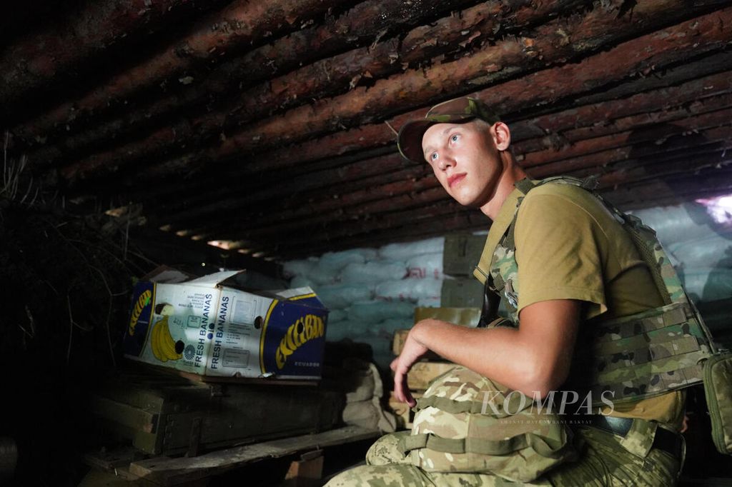 Seorang tentara berada di dalam parit di salah satu lokasi di sekitar garis depan pertempuran di wilayah timur Ukraina, Jumat (8/7/2022).  
