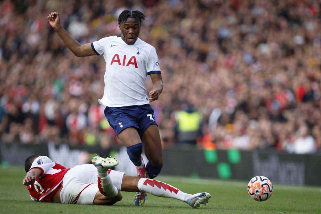 Bek Arsenal, William Saliba (bawah), menekel pemain Tottenham Hotspur, Destiny Udogie, pada laga Liga Inggris di Stadion Emirates, London, Minggu (24/9/2023) malam. Laga itu berakhir imbang, 2-2.