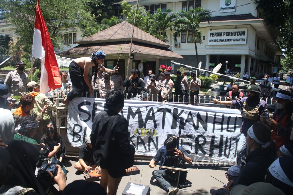 Sejumlah demonstran melakukan aksi teatrikal di depan kantor Perum Perhutani Divisi Regional Jawa Barat dan Banten, Kota Bandung, Jabar, Senin (13/3/2023).