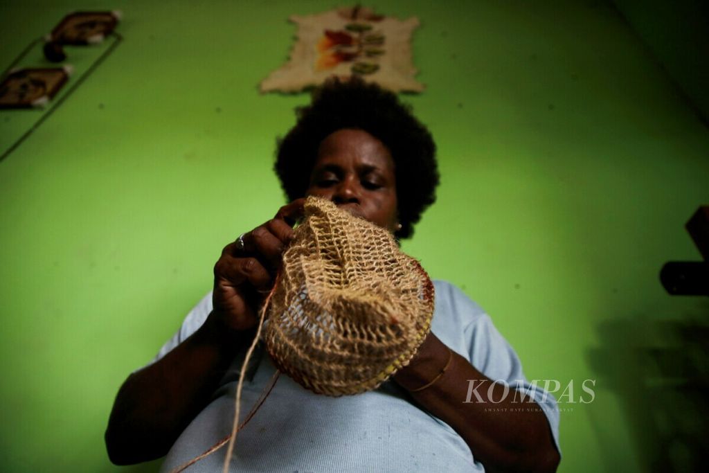 Nia Wenda yang tergabung dalam kelompok wanita Kangguru Jaya memproduksi tas khas Papua atau noken dengan menggunakan bahan baku kulit kayu pohon melinjo di Utikini Baru, Distrik Kuala Kencana, Kabupaten Mimika, Papua, Jumat (1/3/2019). 