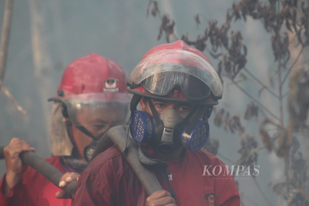 Sejumlah personel Manggala Agni  berupaya memadamkan kebakaran lahan di Desa Deling, Kecamatan Pangkalan Lampam, Kabupaten Ogan Komering Ilir, Sumatera Selatan, Sabtu (26/8/2023). Mereka sudah berada di lokasi itu selama 17 hari. Pemadaman terkendala keterbatasan air dan juga kondisi gambut dangkal yang jika telah terbakar sulit dipadamkan.