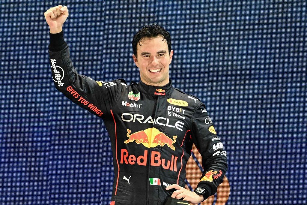 Pebalap tim Red Bull Sergio Perez merayakan kemenangannya di podium pada F1 seri Singapura di Marina Bay Street Circuit, Singapura, Minggu (2/10/2022). 
