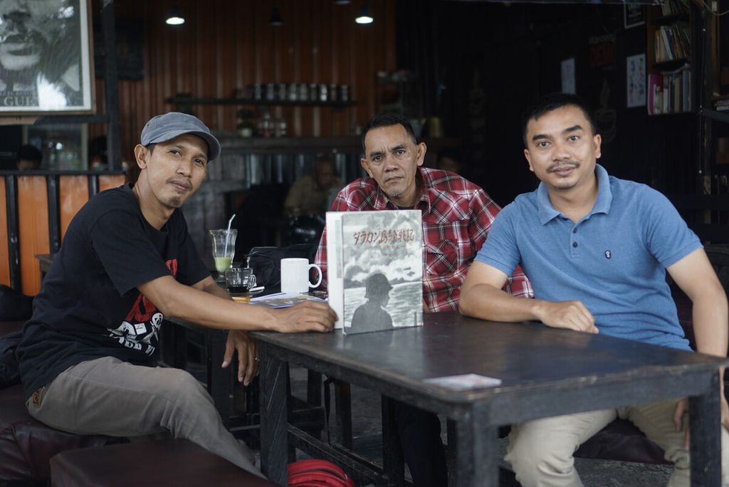 Che Ageng (kiri) dan Yusuf Sofian (31) berpose memegang buku berbahasa Jepang bertajuk "Kekalahan Jepang di Kota Tarakan" di sebuah kedai kopi di Kota Tarakan, Senin (26/9/2022).