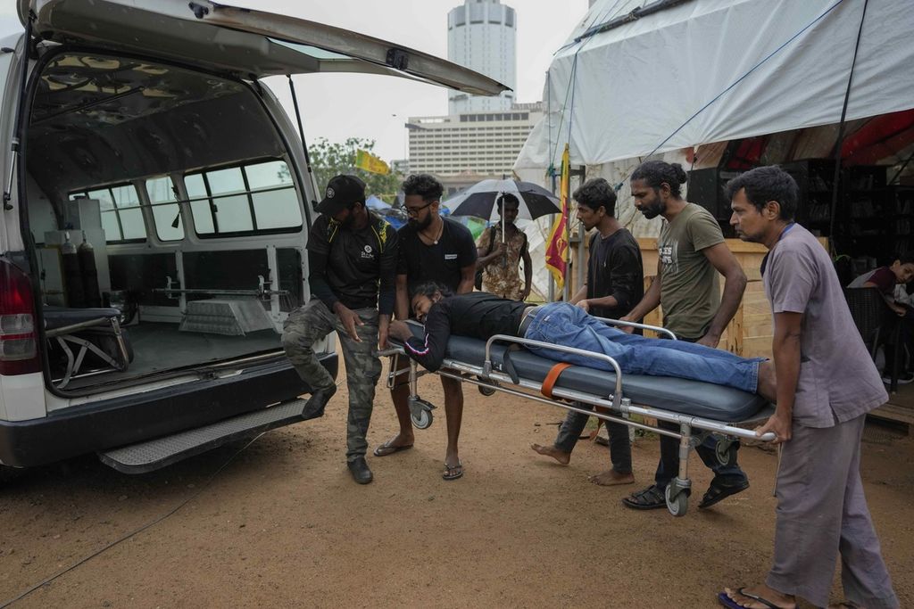 Pendemo dan sejumlah paramedis menggotong warga yang terluka ke dalam ambulans untuk mendapatkan perawatan lebih lanjut seusai pengusiran paksa oleh aparat keamanan Sri Lanka di Colombo, Jumat (22/7/2022).