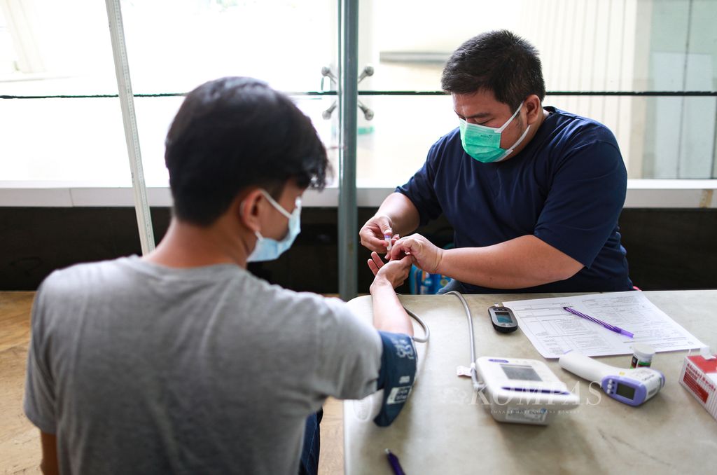 Petugas medis memeriksa gula darah warga sebelum menerima suntikan vaksin Covid-19 dosis kedua di sentra vaksin yang berlangsung di Taman Ismail Marzuki, Cikini, Jakarta Pusat, Kamis (23/6/2022). 
