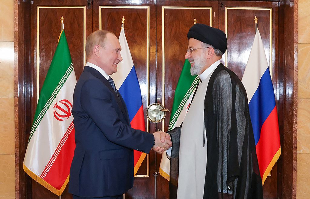 Foto selebaran dari Kantor Kepresidenan Iran menunjukkan Presiden Iran Ebrahim Raisi (kanan) menyambut Presiden Rusia Vladimir Putin yang berkunjung ke Teheran, 19 Juli 2022. 
