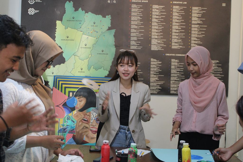 Alya Zahra Sabira (tengah) memberikan saran kepada rekan-rekannya dalam pembuatan poster di Sukabumi Creative Hub. Kota Sukabumi, Jawa Barat, Sabtu (3/6/2023). Poster dari para anggota State of Youth Sukabumi ini dibuat untuk menyambut Hari Lingkungan Hidup Sedunia.