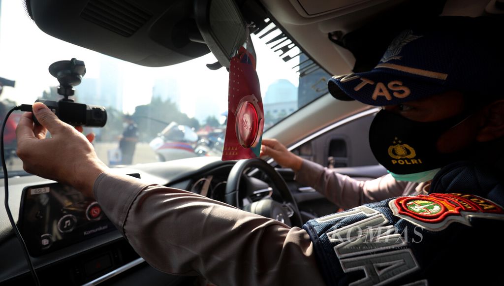 Anggota Brigade Motor Polisi Lalu Lintas Polda Metro Jaya mengoperasikan kamera <i>electric traffic law enforcement</i> (ETLE) bergerak yang terpasang di kaca mobil saat peluncuran di Markas Polda Metro Jaya, Jakarta Selatan, Sabtu (20/3/2021). 